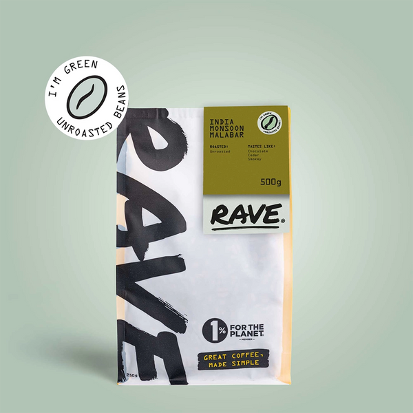 A 500g bag of RAVE COFFEE India Monsoon Malabar AA Green Coffee Beans, featuring spice, clove, and woody notes; unroasted for home roasting; Im green packaging; 1% for the Planet. Displayed on a light green background.