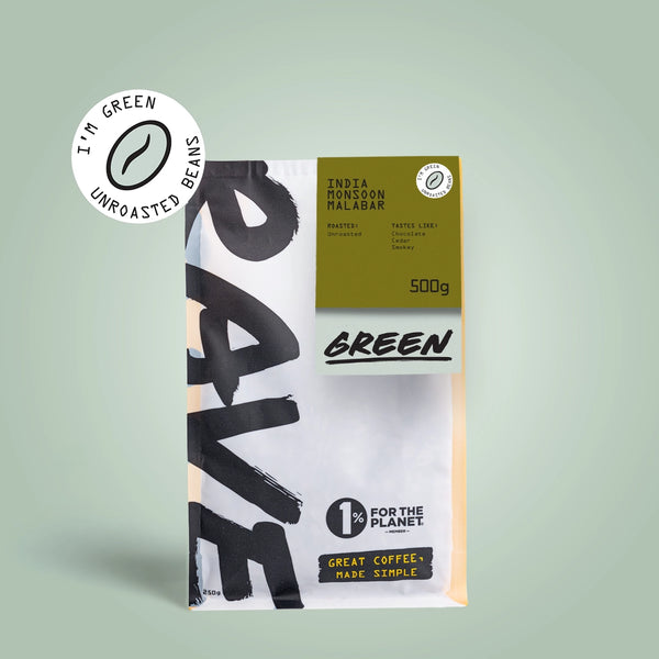 A 500g bag of RAVE COFFEE India Monsoon Malabar AA Green Coffee Beans, featuring spice, clove, and woody notes; unroasted for home roasting; Im green packaging; 1% for the Planet. Displayed on a light green background.