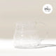 A clear Hario V60 Glass Coffee Server by Hario with a handle rests on a light surface, casting a soft shadow. Made from heat-proof glass, it pairs perfectly with V60 drippers. 