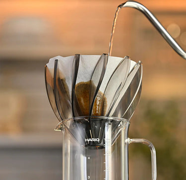 Coffee being poured into a HarioSuiren-Black-02 with a blurred background