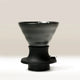 The Hario Switch V60 Ceramic Immersion Dripper (Size 02) by Hario, in sleek black, features an hourglass shape with a wide top and narrow base, shown against a light background—ideal for perfecting V60 brewing.