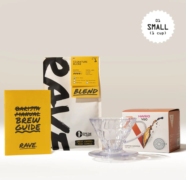 The Hario V60 Dripper Filter Coffee Gift Set by Hario, featuring a clear dripper and fresh Rave signature blend coffee, is arranged with a yellow brew guide and packaging on a white surface against a beige background.