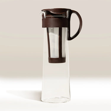 The Hario Cold Brew Coffee Pot by Hario features clear glass with a dark brown handle, lid, and built-in filter—perfect for preparing and serving tea or cold brew concentrate.