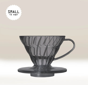 A Hario V60 Black Plastic Coffee Dripper with handle, crafted for one-cup filter coffee brewing, is set against a light beige background. 