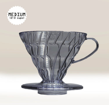 Black, semi-transparent plastic coffee filter with handle on a light beige background