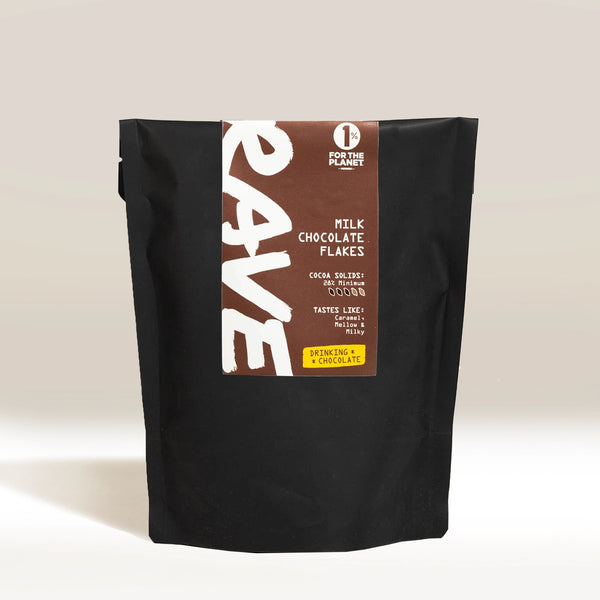 A black pouch labeled RAVE COFFEE Drinking Chocolate Flakes stands upright, featuring "FOR THE PLANET," 38.1% cocoa content, and describes the product as perfect hot chocolate drinking flakes.