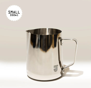 The Crema Pro Milk Steaming Jug or Pitcher, 12 OZ/350ml, has a handle and “SMALL 350ml” labeled in the top left. The Crema Pro logo appears on the lower front of this versatile stainless steel latte art pitcher.