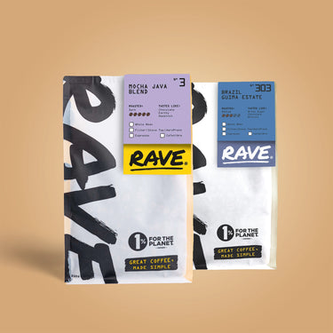 Two white Ravecoffee bags from the Nut Lover Coffee Bundle are displayed on beige. One features Mocha Java Blend #3 (low acidity), the other Brazil Guiza Estate #303. Both bags display the 1% for the Planet badge.