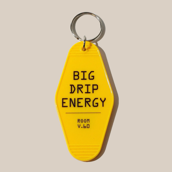 The Rave Keyring by RAVE Coffee is a yellow, vintage-style motel keyring with a silver ring, featuring BIG DRIP ENERGY and ROOM V.60 in black text—ideal for those who love unique keyrings.