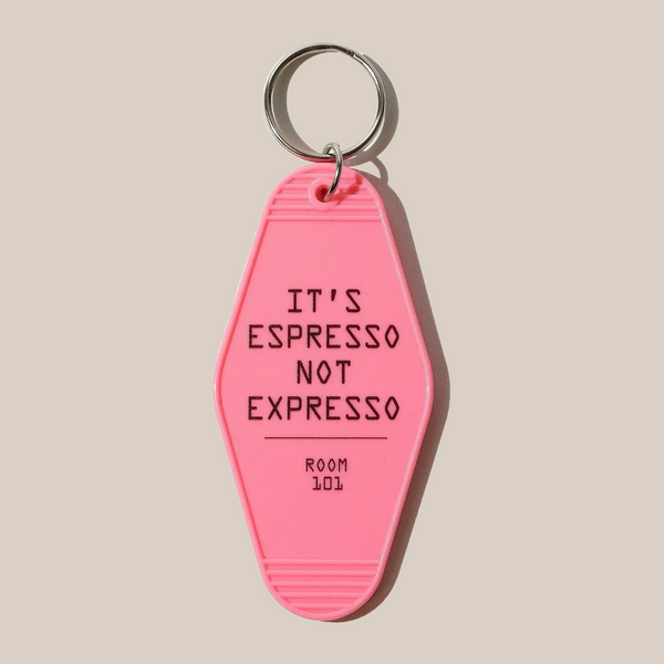 The Rave Keyring by RAVE Coffee features a pink vintage motel design with "ITS ESPRESSO NOT EXPRESSO" and "ROOM 101" in black uppercase letters, set on a beige background—ideal for cool keyring enthusiasts.