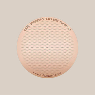 A round, gold-toned stainless steel Cafe Concetto Reusable AeroPress Metal Filter (Superfine) with 