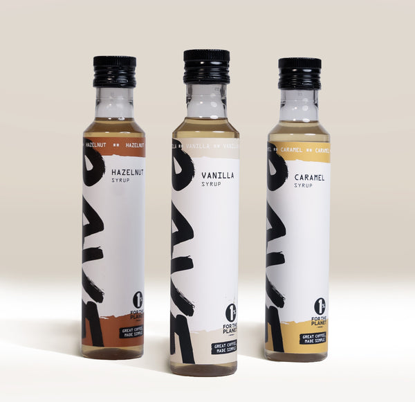 RAVE COFFEE Best Selling Syrup Set featuring three glass bottles of flavored coffee syrups labeled hazelnut, vanilla, and caramel.