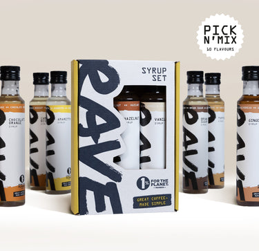 Six glass bottles of flavored coffee syrup from the Pick N’ Mix Syrups Set arranged around a rectangular display box containing a syrup trio.