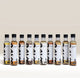 Ten glass bottles of RAVE Coffee Pick N’ Mix Syrups Set in a row, each with a white label featuring the flavor name and a large black brushstroke graphic.