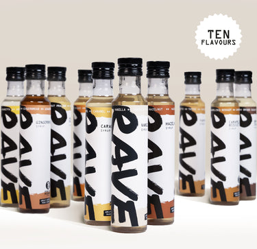 Ten bottles of Rave Coffee Syrups in various flavors are arranged in two rows. Each bottle has a white label with RAVE COFFEE in bold black letters. Text in the corner reads TEN FLAVOURS in all caps.