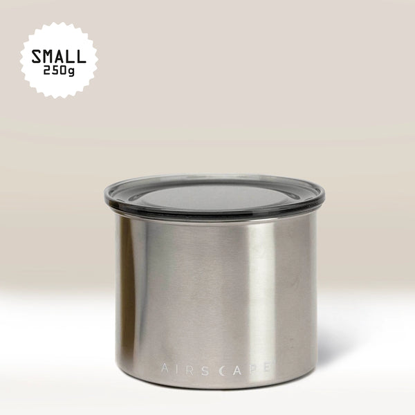 The Planetary Design Stainless Steel Airscape Coffee Storage Container, shown with a clear lid and labeled "SMALL 250g," is ideal for keeping coffee fresh against a light, neutral background.