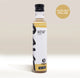 A bottle of Rave Coffee Syrups by RAVE COFFEE, featuring a black cap, white and gold label, and the 1% for the Planet emblem. The “Hazelnut Praline” text is highlighted in a tan circle. This UK-made flavoured coffee syrup is perfect for adding rich, nutty sweetness to your favourite coffee syrups collection.