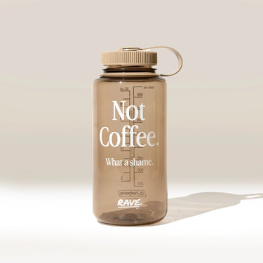Clear water bottle with 'Not Coffee. What a shame.' text on a beige background