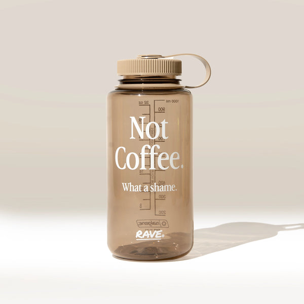 Clear water bottle with 'Not Coffee. What a shame.' text on a beige background