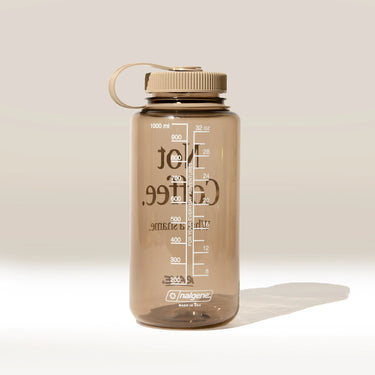 Brown Nalgene water bottle with measurement markings on a light beige background