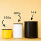 Three Planetary Design Airscape Coffee Storage Containers—yellow, white, and black—labeled 250g, 500g, and 1kg sit on wood. Each uses Airscape technology to remove oxygen and keep your coffee fresher for longer.