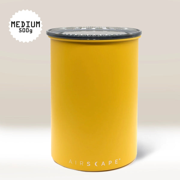 The Yellow Airscape Coffee Storage Container by Planetary Design (500g, medium, black lid) is shown on a light beige background. It features Airscape technology for oxygen removal and has "AIRSCAPE" printed in white at the bottom.