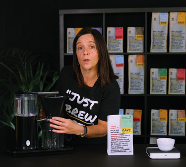 A photo of a woman showcasing the filter brewing machine, with a RAVE coffee blend.