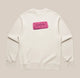 Introducing the Pink Bourbon Sweatshirt from RAVE COFFEE – a limited edition, cream-colored sweatshirt showcasing a playful graphic of a pink rectangular biscuit labeled “BOURBON,” complete with small black dots and centered on the chest. Perfect for anyone looking to express their unique style with a fun twist.