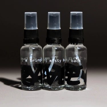 Three RAVE COFFEE RDT Bottles (I'm Bringing Misty Back) are arranged side by side on a gray surface, each clear with black and white text—perfect for controlling coffee static using the Ross Droplet Technique.